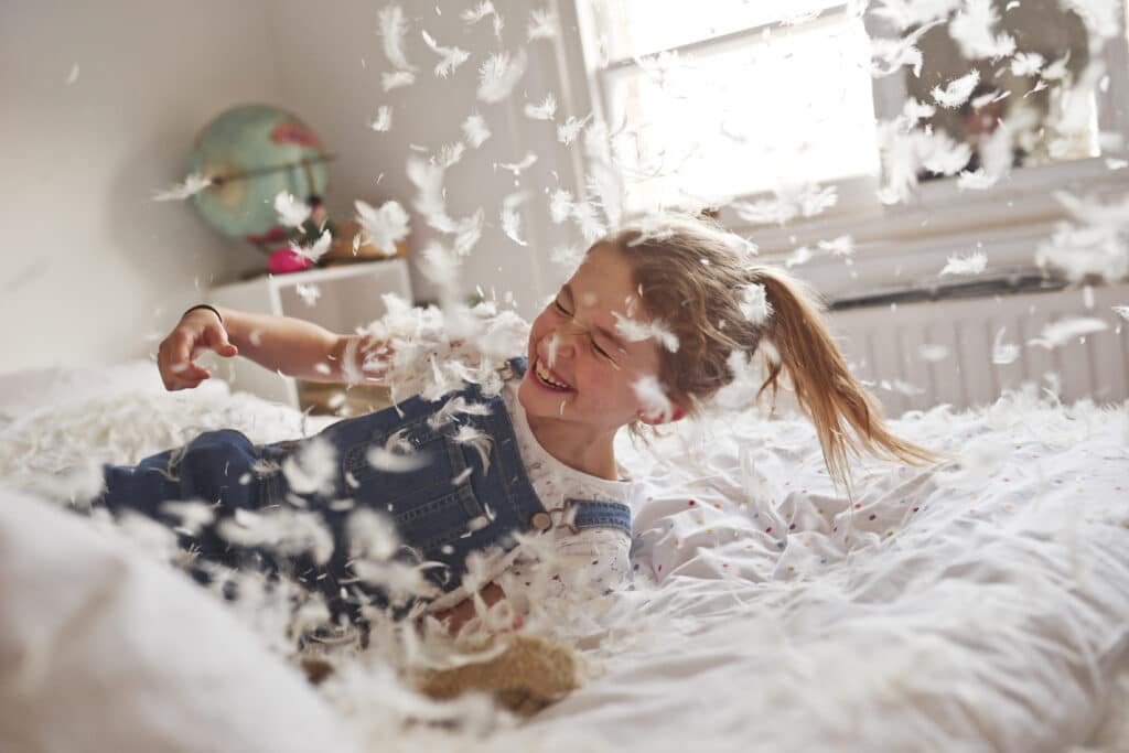Girl falling on feather pillow fight bed